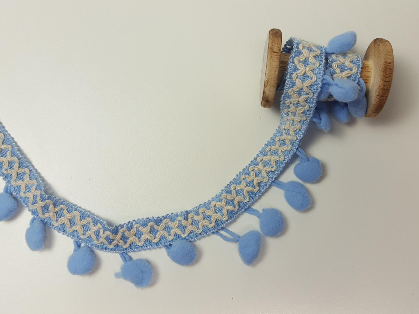 Pompons Borte Kreuz hellblau/natur